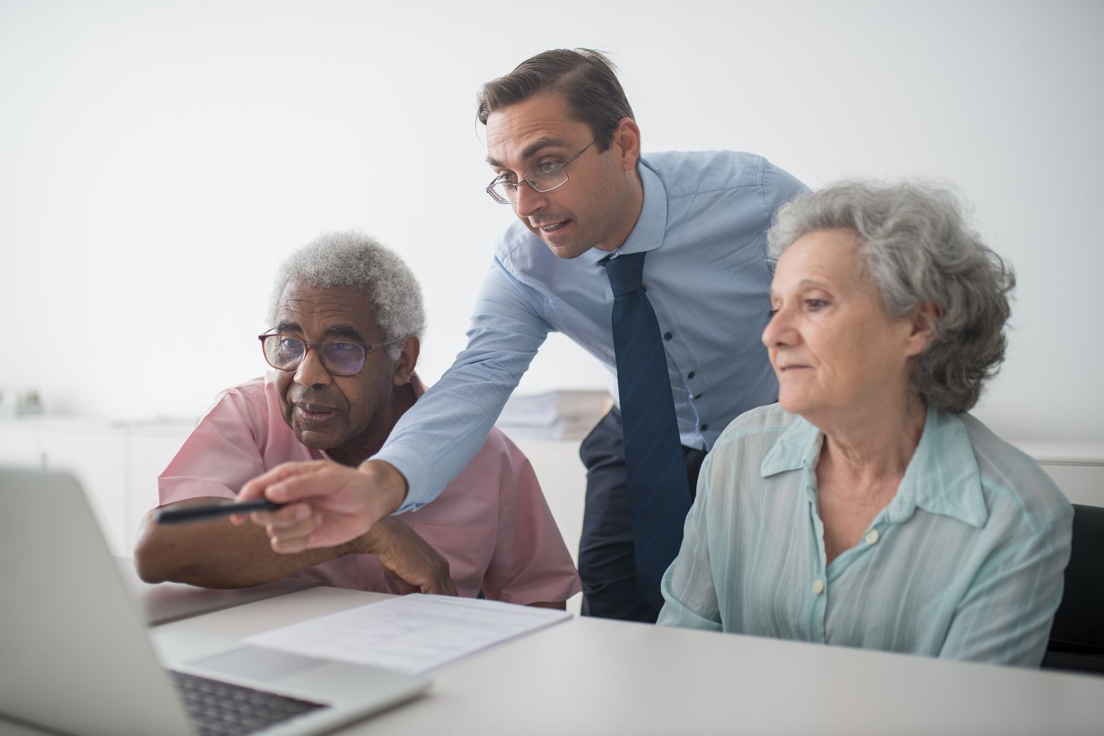 An adviser going through a plan on screen with an older couple