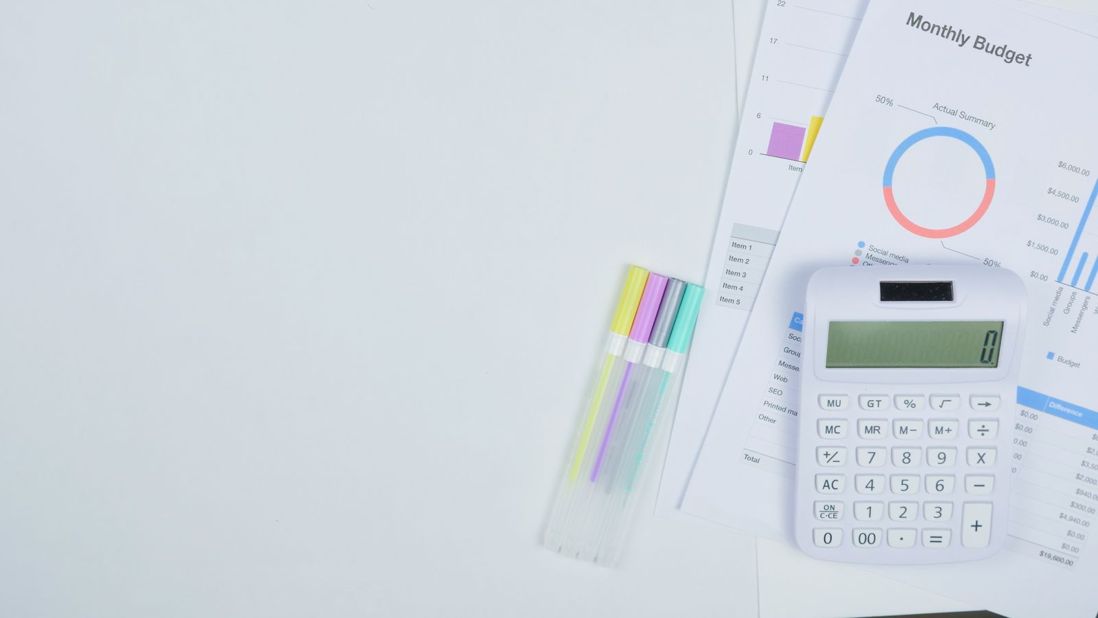 A monthly budget printout on a desk with a calculator